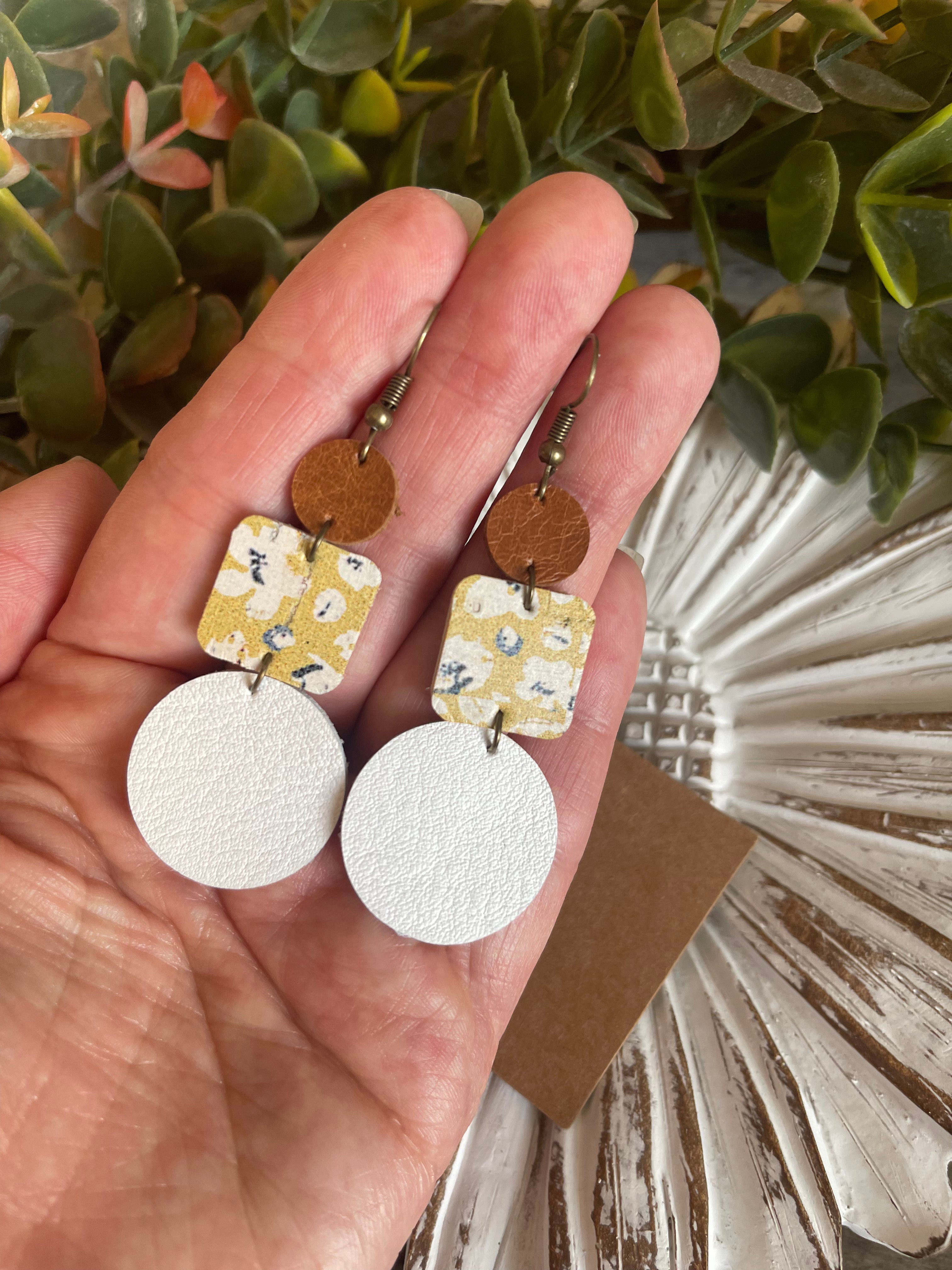 Mustard yellow floral cork earrings. White circle leather with wood accents.