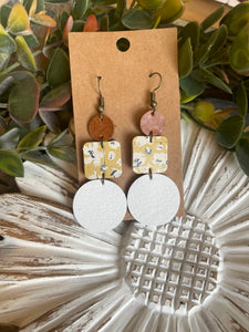 Mustard yellow floral cork earrings. White circle leather with wood accents.